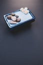 Vertical shot of a bowl and small rocks on a black surface Royalty Free Stock Photo