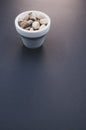 Vertical shot of a bowl and small rocks on a black surface Royalty Free Stock Photo