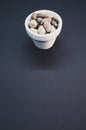 Vertical shot of a bowl and small rocks on a black surface Royalty Free Stock Photo