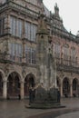 Vertical shot of the Bremen Roland statue with a medieval building in the background on a gloomy day