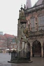 Vertical shot of the Bremen Roland statue with a medieval building in the background on a gloomy day