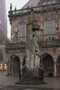 Vertical shot of the Bremen Roland statue with a medieval building in the background on a gloomy day