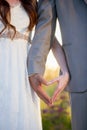 Vertical shot of the bride and the groom making a heart shape with their hands Royalty Free Stock Photo