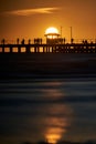 Vertical shot of a bridge over a lake at the Melbourne Pier during an orange sunset