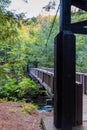 Vertical shot of a bridge over a river in a park in autumn in Michigan, the US