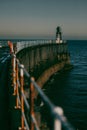 Vertical shot of a bridge on the sea with lighthouse at the end of it Royalty Free Stock Photo