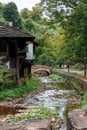 Vertical shot of a bridge in a stream near an old historical and typical houses in Bulgarian