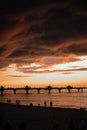 Vertical shot of a bright orane sunset sky over the pier of Baltic Sea