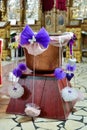 Vertical shot of a bronze jar decorated with ribbons and butterflies on a pedestal in a church