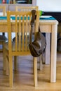 Vertical shot of a brown leather bag hanging on a wooden chair