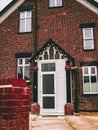 Vertical shot of a brown and orange  house with a white door Royalty Free Stock Photo