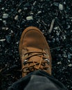 Vertical shot of a brown sneaker on a gravel surface Royalty Free Stock Photo