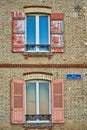 Vertical shot of a building facade with old windows with wooden shutters, France Royalty Free Stock Photo
