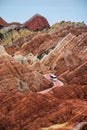 Vertical shot of a bus driving on the road in Danxia landform, Zhangye, Gansu Province Royalty Free Stock Photo