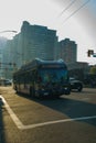 Vertical shot of the 24 bus to Lynn Valley driving down a sunny road in downtown Vancouver