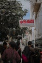 Vertical shot of busy and crowdy street in Yogyakarta with people walking between buildings and tree