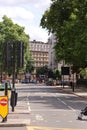 Vertical shot of busy street in London, full of people, trees, street signs, transport, buildings Royalty Free Stock Photo