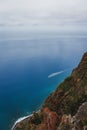 Vertical shot of Camara Lobos on the island of Madeira with clean, blue water and a cloudy sky Royalty Free Stock Photo