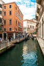 Vertical shot of a canal surrounded by typical buildings in Venice, Italy