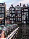 Vertical shot of the canals of Amsterdam with crooked canal buildings and canal boats