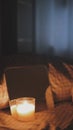 Vertical shot of a candle in front of a small mirror on a bed, artsy aesthetic