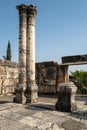 Vertical shot of Capernaum synagogue columns with a blue sky in the background, Israel