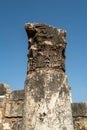 Vertical shot of Capernaum synagogue ornamented column with a blue sky in the background, Israel
