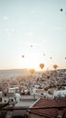 Vertical shot of Cappadocia's cityscape with hot air balloons in the bright sky at the sunrise Royalty Free Stock Photo