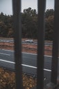 Vertical shot of a car in tstreet seen through the fence Royalty Free Stock Photo