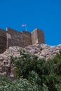 Vertical shot of the Castle of Monolithos with a Greece flag Royalty Free Stock Photo