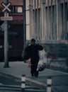 Vertical shot of a Caucasian homeless man carrying two bags with recyclable cans and bottles Royalty Free Stock Photo