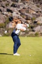 Vertical shot of a Caucasian male golfer playing a shot on the fairway on a golf course Royalty Free Stock Photo