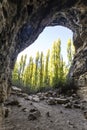 Vertical shot of a cave with trees on the background in the Senda de la Vega park in Segovia, Spain Royalty Free Stock Photo