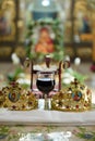 Vertical shot of the ceremonial crowns and a glass of wine as orthodox wedding accessories. Royalty Free Stock Photo