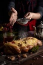 Vertical shot of a chef with an apron sprinkling powdered sugar with a sieve on a homemade pastry Royalty Free Stock Photo