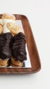 Vertical shot of choux pastry buns and eclairs on a wooden plate Royalty Free Stock Photo