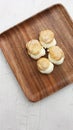 Vertical shot of choux pastry buns on a wooden plate Royalty Free Stock Photo