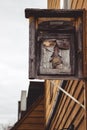 Vertical shot of Christmas tree carved on an old wooden sign hanging on an exterior wooden wall Royalty Free Stock Photo