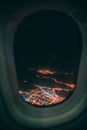 Vertical shot of a city at night taken from an airplane window Royalty Free Stock Photo