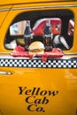 Vertical shot of a classic American yellow cab taxi with coca cola bottles and a hamburger