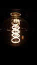 Vertical shot of a classic Edison lightbulb on dark background with space for text