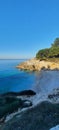 Vertical shot of the coast of a clear ocean surrounded bu rocks and cliffs Royalty Free Stock Photo