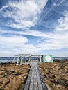 Vertical shot of a coastal path leading to a `Water Sports` sign and the blue sea on a cloudy day Royalty Free Stock Photo