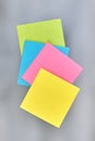 Vertical shot colored sticky paper notes on blurred background. Royalty Free Stock Photo