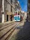 Vertical shot of a colored tram in a narrow street in Lisbon, Portugal