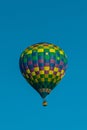 Vertical shot of a colorful Air Balloon flying with a blue sky in the background Royalty Free Stock Photo