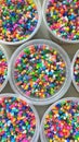 Vertical shot of colorful beads in plastic buckets for creating accessories