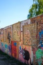 Vertical shot of a colorful brick wall with art paintings at a park
