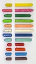 Vertical shot of colorful broken crayons isolated on a grey background