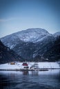 Vertical shot of colorful houses on a snowy shore against mountains in winter Royalty Free Stock Photo